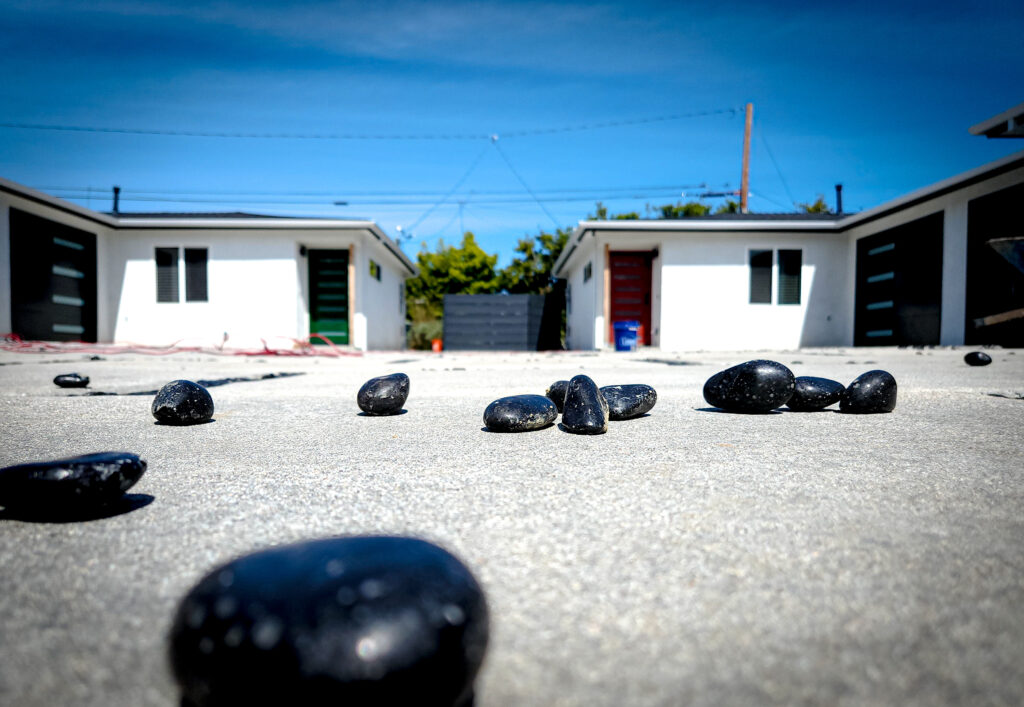 Black pebbles ready to fill concrete paver joints &mdash; Costa Mesa landscape project by Abode Landscaping