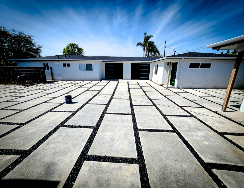 Staggered concrete pavers with black pebble joints &mdash; Costa Mesa landscape project by Abode Landscaping