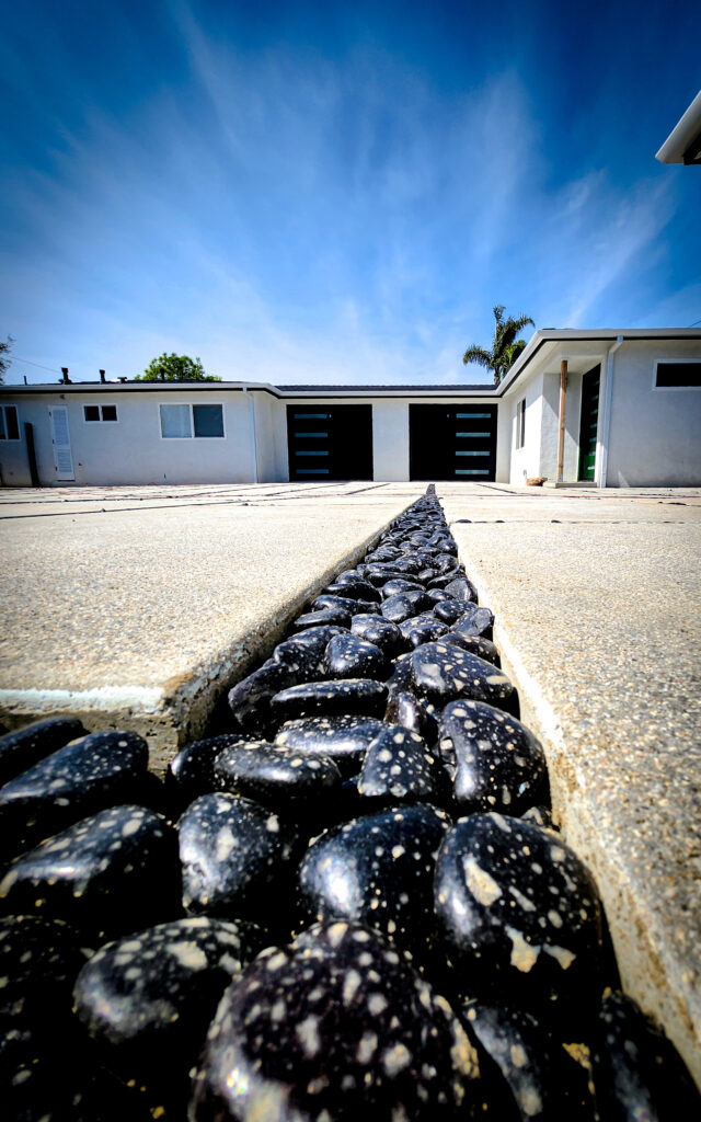 Close-up of black pebble joint between concrete pavers &mdash; Costa Mesa landscape project by Abode Landscaping