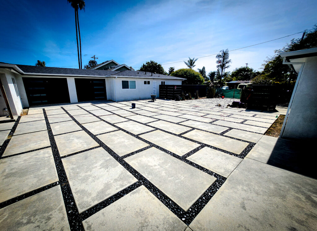 Angled concrete paver driveway beside a modern home &mdash; Costa Mesa landscape project by Abode Landscaping