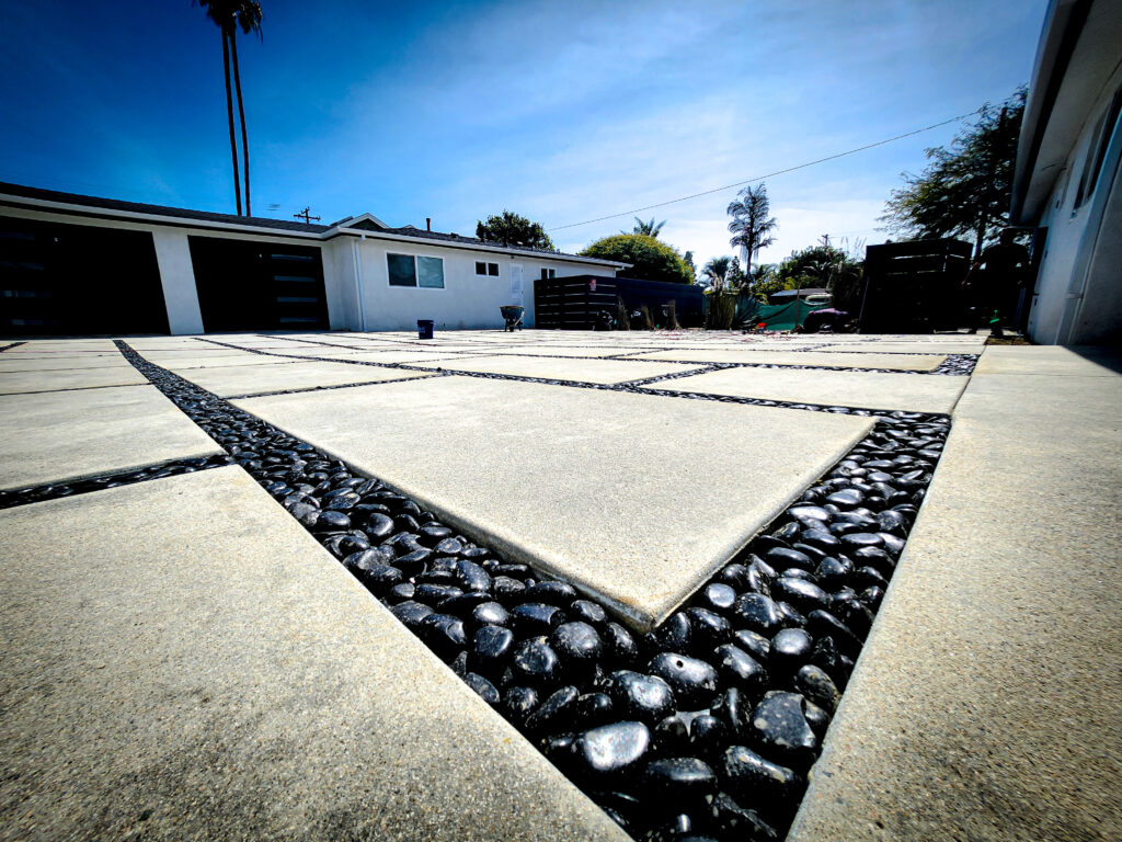 Large concrete pavers with black pebble joints on a modern driveway &mdash; Costa Mesa landscape project by Abode Landscaping